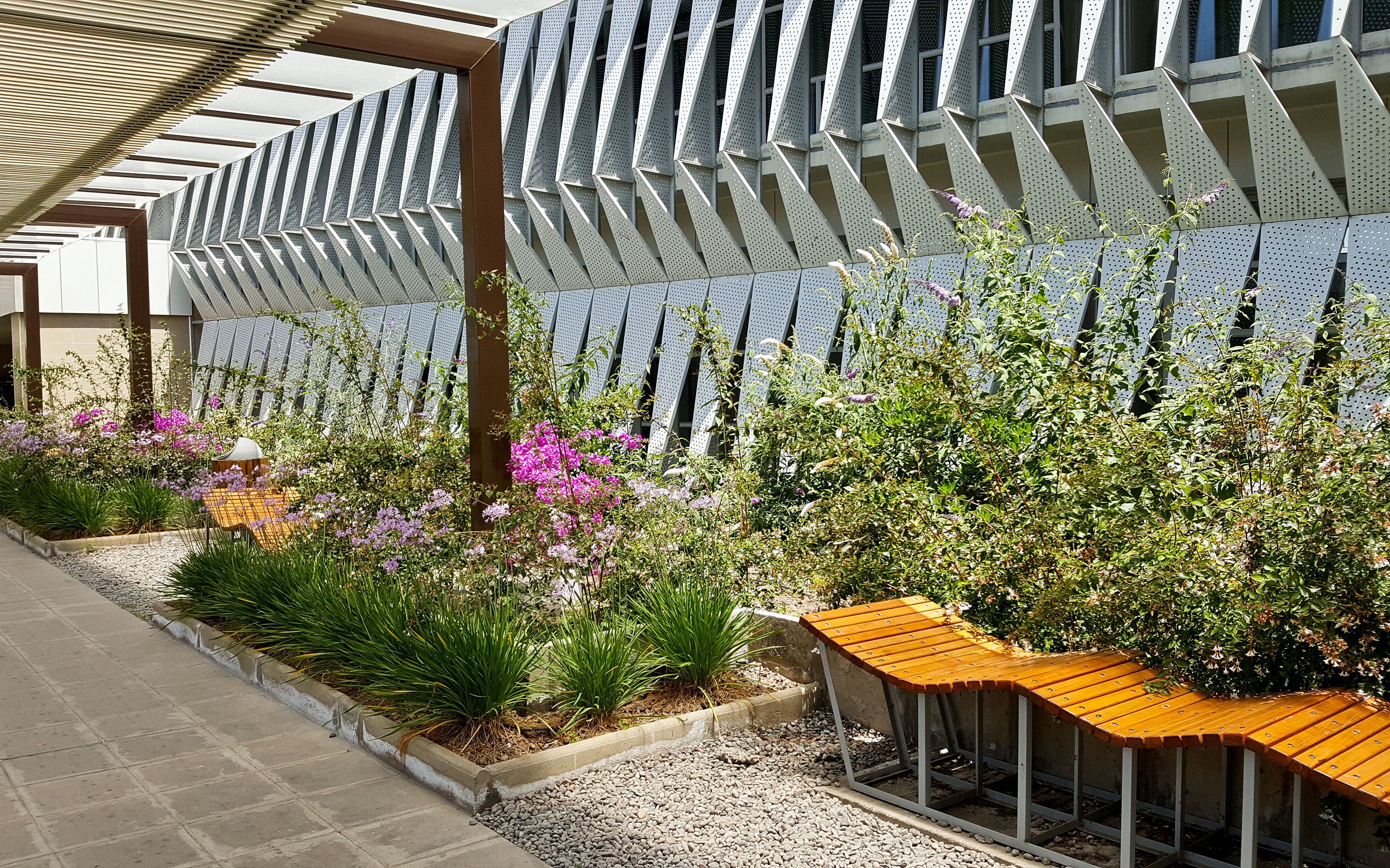 Besides the stunning appearance the various green roofs reduce air-conditioner loading. Plant beds with flowers and wave-like benches